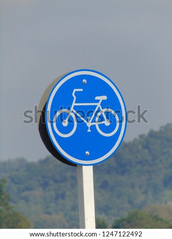 Traffic signs for bicycle lane, mountain and bright blue sky background. 