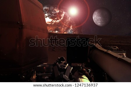 Mission InSight Mars Lander in shadow  near the red  planet and moon with lens flare. Elements of this image were furnished by NASA.