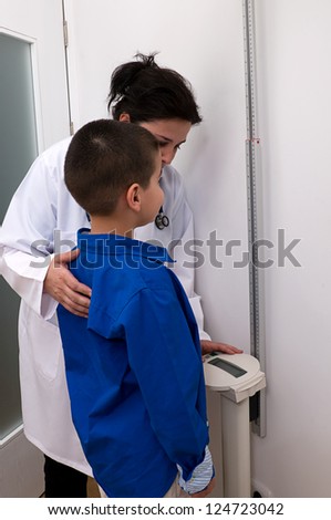 Pediatrician measuring height of a little child at clinic