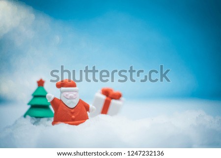 Santa Claus dolls and Christmas tree and Gift Box on snow 
