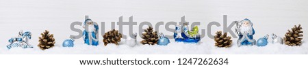 Winter snow scene with blue Christmas decorations on the snow, light wooden background, copy space
