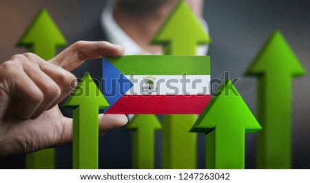 Nation Growth Concept, Green Up Arrows - Businessman Holding Card of Equatorial Guinea Flag
