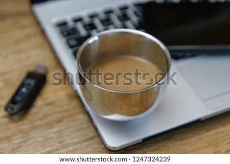 Coffee on modern laptop - ultrabook on wooden table with flash disk and external hard drive