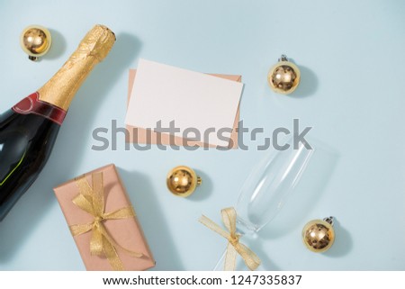 Clipboard and Bottles of champagne with golden decorations. Flat lay, top view trendy holiday concept.