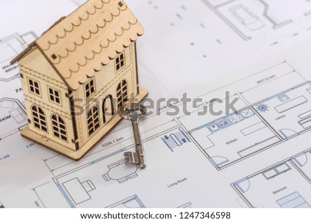 Wooden house on project with real key, closeup