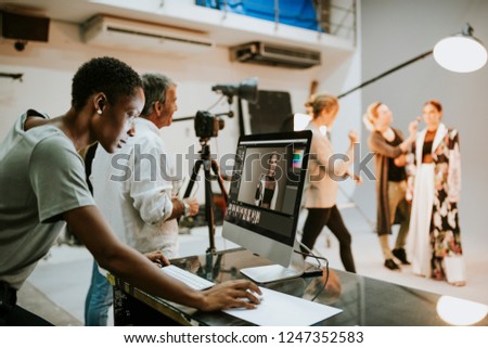 Art director checking photos on a monitor Royalty-Free Stock Photo #1247352583