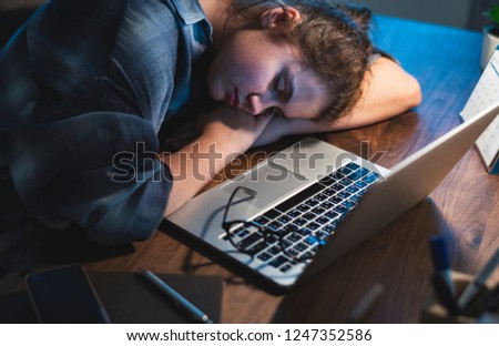 Teen girl asleep by her laptop Royalty-Free Stock Photo #1247352586