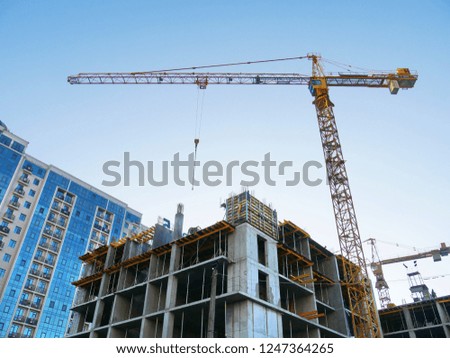 Building site background. Two cranes near building. Concrete building under construction.