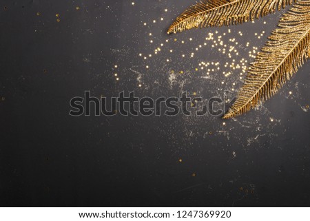 Christmas composition of golden Christmas toys and decoration elements on a black background.