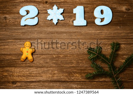 Gingerbread cookies over wooden background. Flat lay festive composition with copy space. New 2019 year holiday frame.