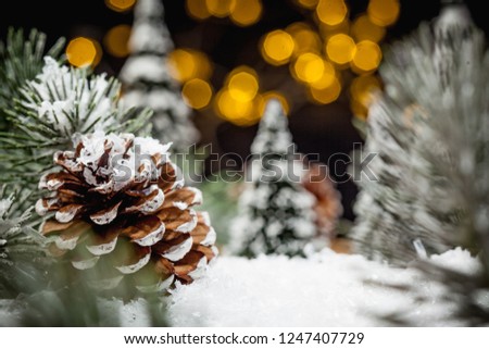 Snow covered seasonal winter forest diorama with christmas decoration elements and blurred bokeh light background