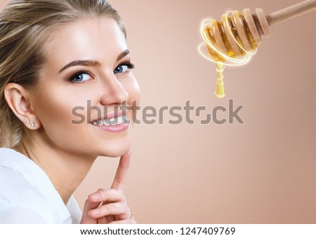 Young woman and honey spoon prepare for facial mask. Honey treatment concept. Royalty-Free Stock Photo #1247409769