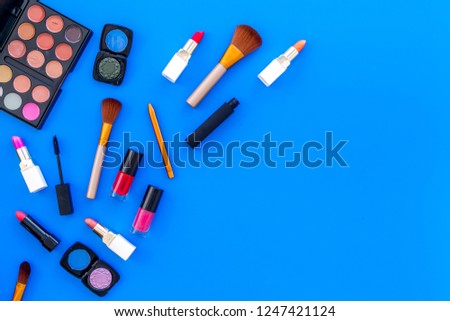 female desk with decorative cosmetics for make up blue background top view mockup