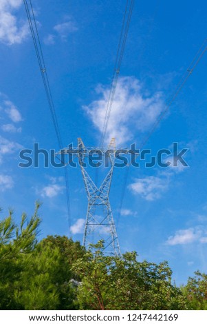 Pylons of high-voltage power lines and a blue sky with clouds