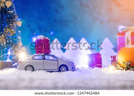 Toy car carries gifts in the Christmas and new year's eve on a blue background. The concept of holiday shopping and discounts