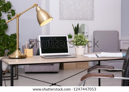 Stylish and comfortable workplace with modern laptop in office