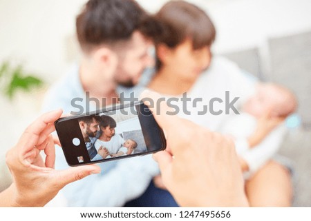 Smartphone makes picture of happy parents and newborn baby