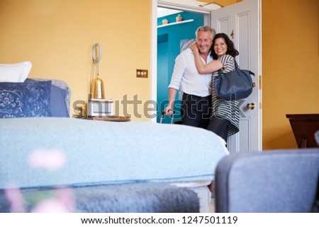 Middle aged couple opening the door to their hotel room