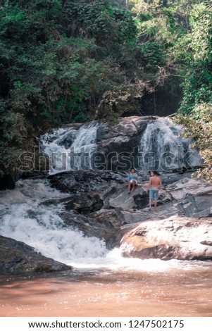 young couple men and woman at waterfall, Mae Sa waterfall Chiang Mai Thailand