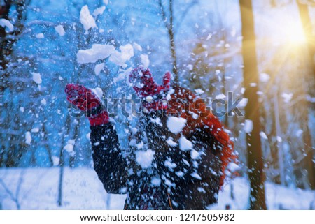 Dynamic photo of happy young woman playing in the snowfall. New Year, Christmas, winter and holyday concept.