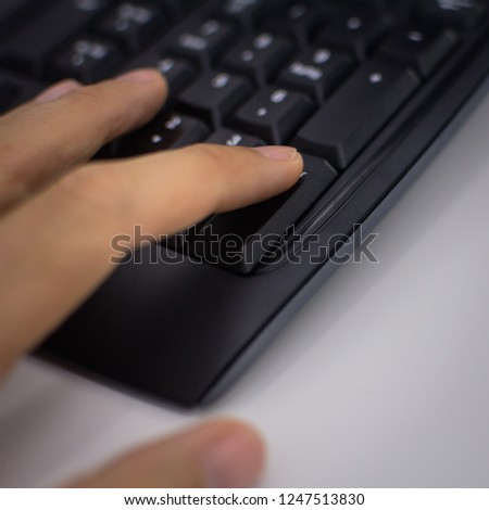 Soft blur of a person fingers  typing in a black keyboard. 