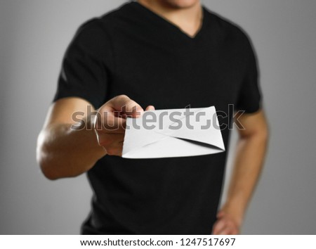 A man holding an envelope. Isolated on grey background