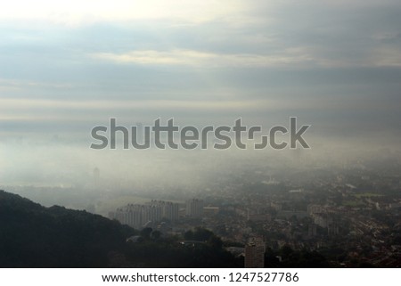 View from a hill looking down on a town in a misty morning                   