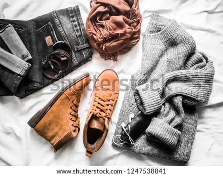 Set of women's outfits autumn, winter clothes  - jeans, gray pullover oversize, suede brown boots. Fashionable casual clothes for walks, flat lay. On a light background     