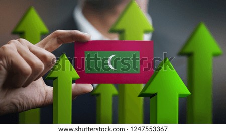 Nation Growth Concept, Green Up Arrows - Businessman Holding Card of Maldives Flag