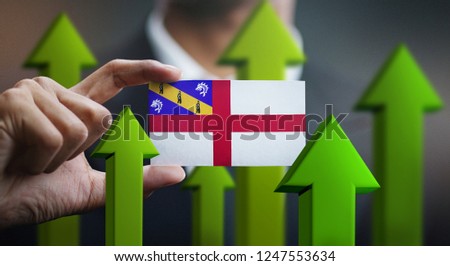 Nation Growth Concept, Green Up Arrows - Businessman Holding Card of Herm Flag 