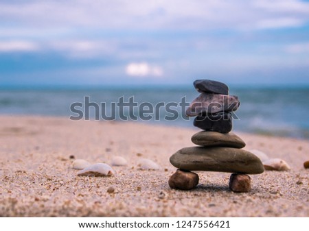 Balance of Stone arrangements on the beach with blurry sea background. 