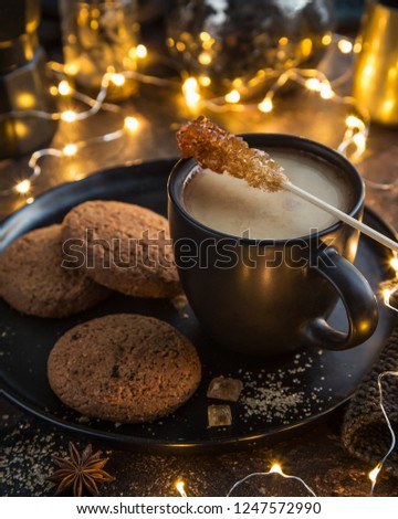 cuf of tea with milk and cookies, dark background, selective focus