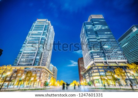 Asia Business concept for real estate and corporate construction - looking up view of panoramic urban city skyline view under blue night in tokyo, Japan with tilt shift, miniature, blur effect
