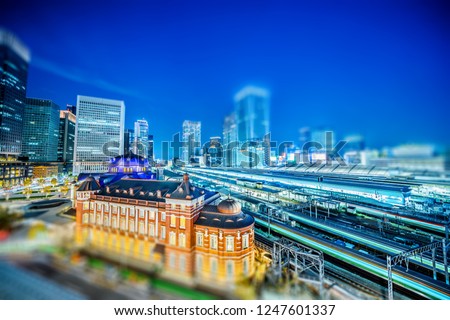 Asia Business concept for real estate and corporate construction - night view of tokyo station with train railroad under neon sky in tokyo, Japan with tilt shift, miniature, blur effect