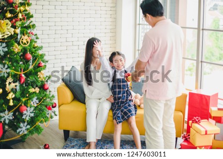 Dad prepares and gives gifts to his daughter, with a mother next to her daughter. To celebrate Christmas and New Year. Families celebrate Christmas and New Year's conception.