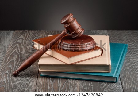 Books, a judge's gavel and a sound block on wooden table. Learning jurisprudence, juridical concept.