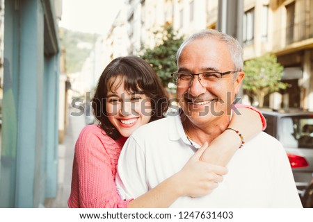 Portrait of a mature father with his young daughter laughing on the street. Focus on him Royalty-Free Stock Photo #1247631403