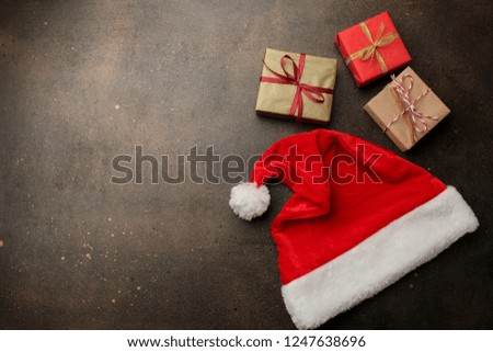 Red Santa Claus hat and gifts on a dark brown background. with space for text. Christmas. new Year.