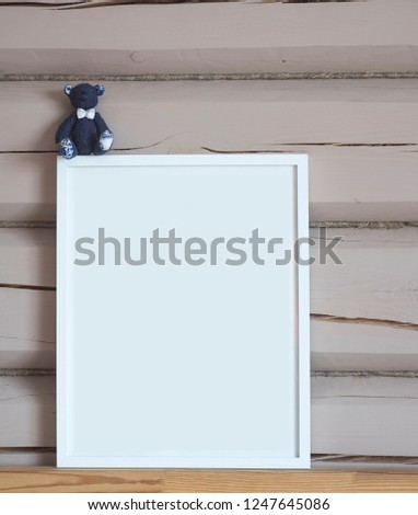 White paper blank interior poster, with blue bear toy, isolated vertical mock up with frame on beige wooden wall background, children theme 