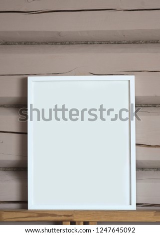 White paper blank interior poster, isolated vertical mock up with frame on beige wooden wall background.