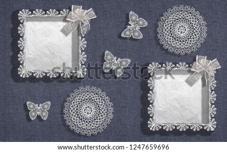 Two frames for a photo or the text from lace on a background of the blue denim fabric decorated with lacy napkins and butterflies. Decoration for a wedding or anniversary.