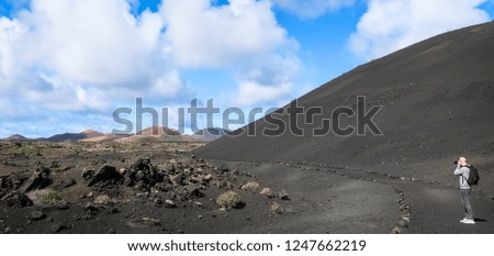 Landscape photographer in volcano landscape. Photographs volcanic mountains and lava fields.