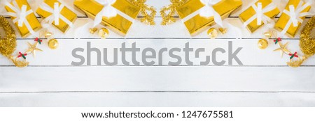 gold gift boxes and glittering Christmas decorating items on white wood panel background, decoration item and copy space,background can be used for display or montague your products