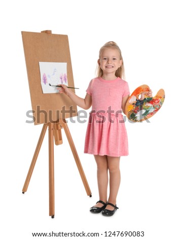 Child painting picture on easel against white background