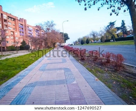 A beautiful wide angle photo of the popular San Luis street, which is located in north of Madrid, in the neighborhood of Manoteras, in Spain, Europe. The photo was taken in fall in the evening.