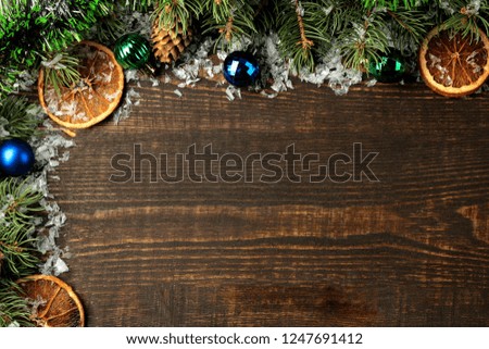 New Year and Christmas frame for text with a Christmas tree and colored Christmas decorations on a brown background. view from above.