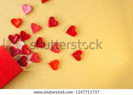 Valentine's day concept. gift for Valentine's Day, a red box with sweet hearts on a gold background. Pictures of Love. selective focus.
