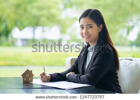Young businesswoman are calculating the cost of buying a new home from real estate agent and plan on long-term home purchase contracts.                               