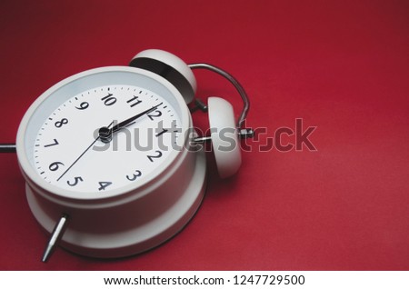 Close up.White Alarm Clock isolated Placed on a red background.copy space.