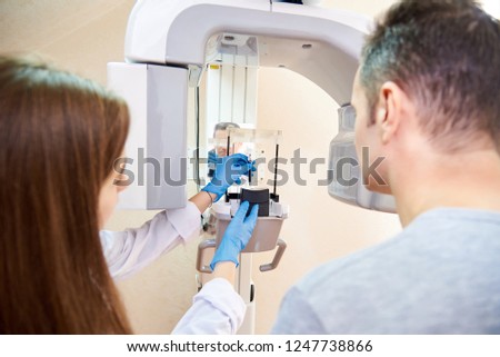 doctor and patient next to x-ray machine. Computer diagnostics. dental tomography Royalty-Free Stock Photo #1247738866